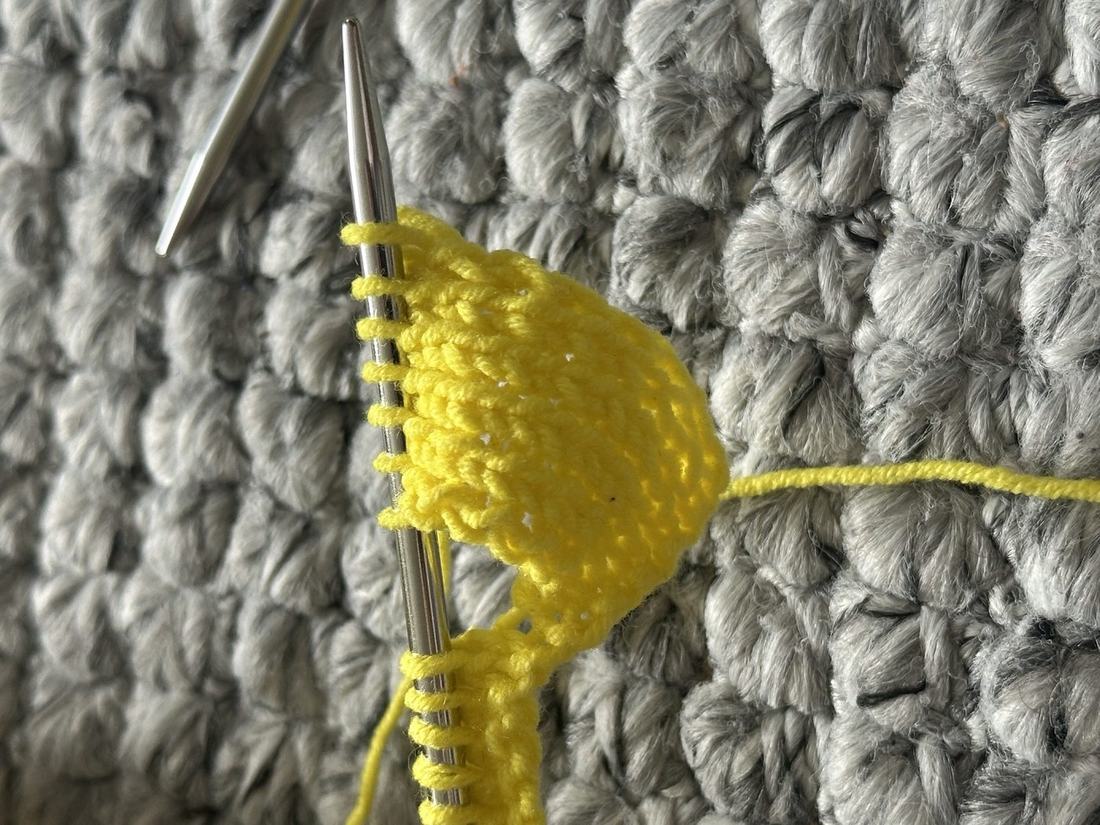 Yellow spikelet stitch swatch on the needles