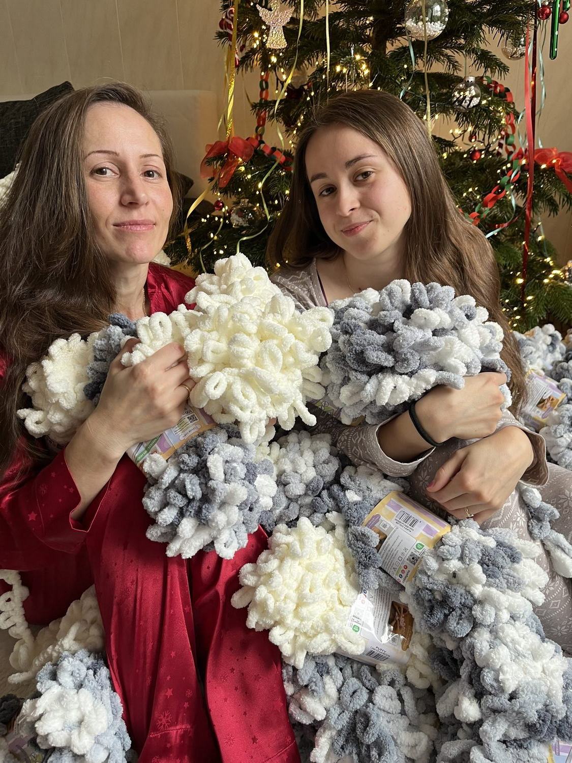 The two friends behind GalexCraft, surrounded by yarn